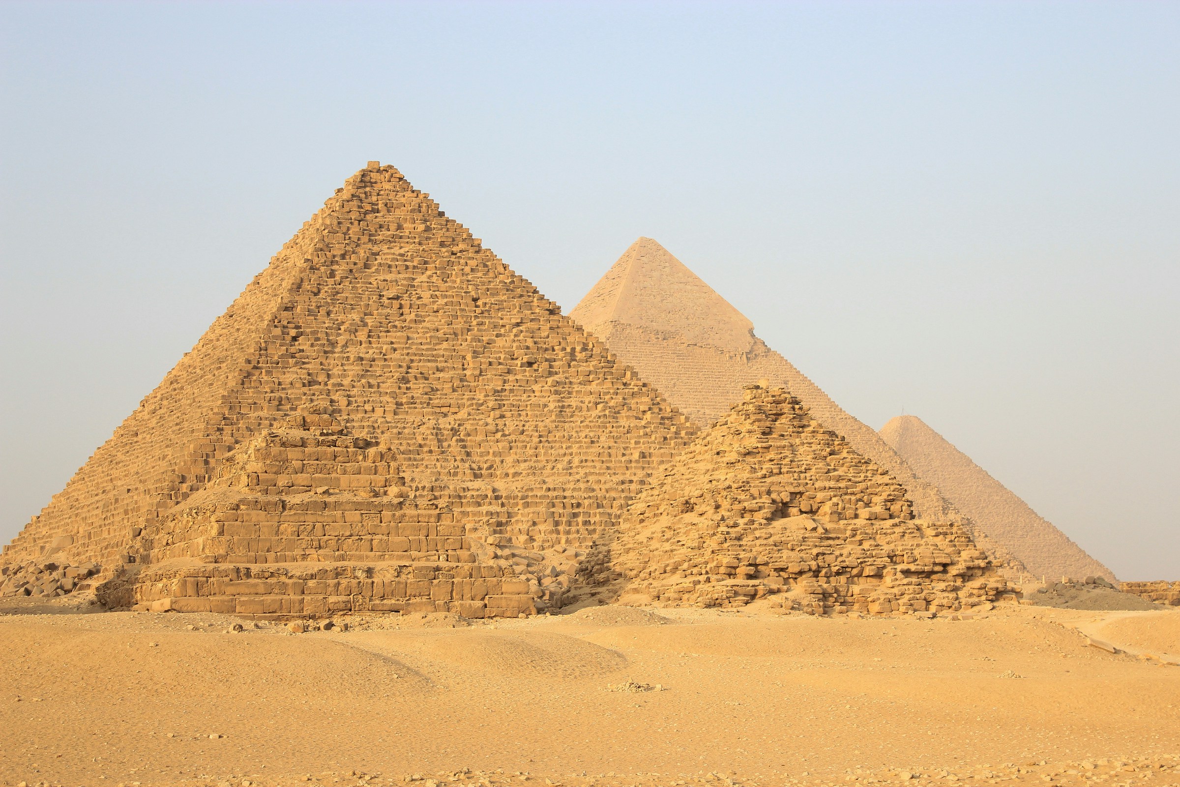 A pyramid on the Giza plateau rising from open desert under a clear sky